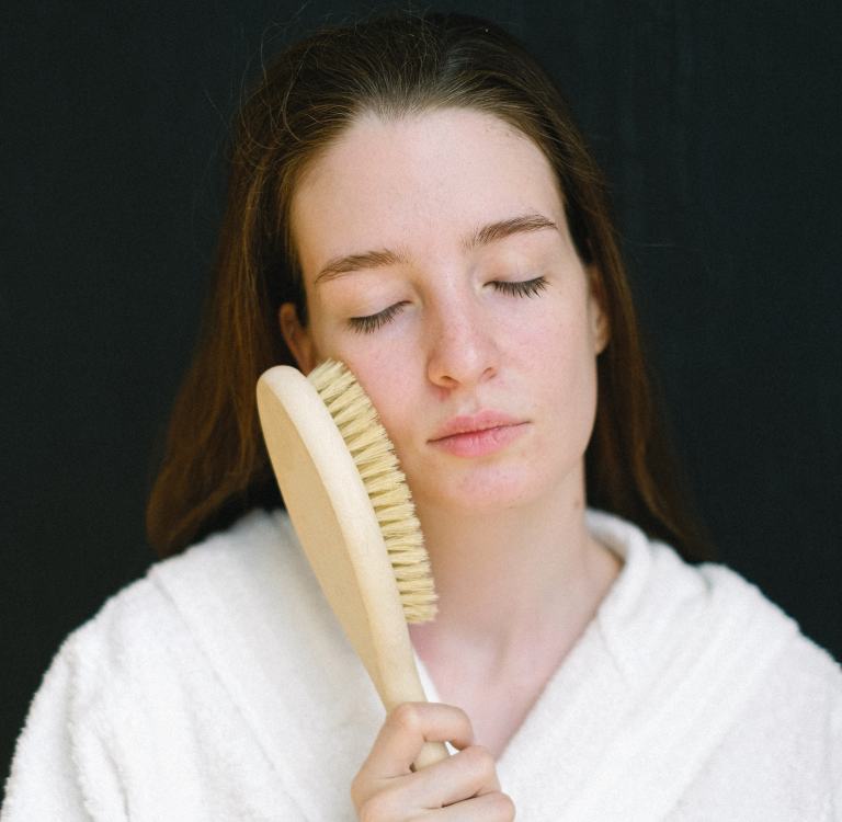 femme avec une brosse à sec contre le visage